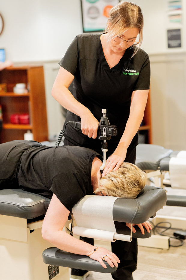 A patient a Snow Holistic Health receives instrument-assisted soft tissue treatment on her neck. 